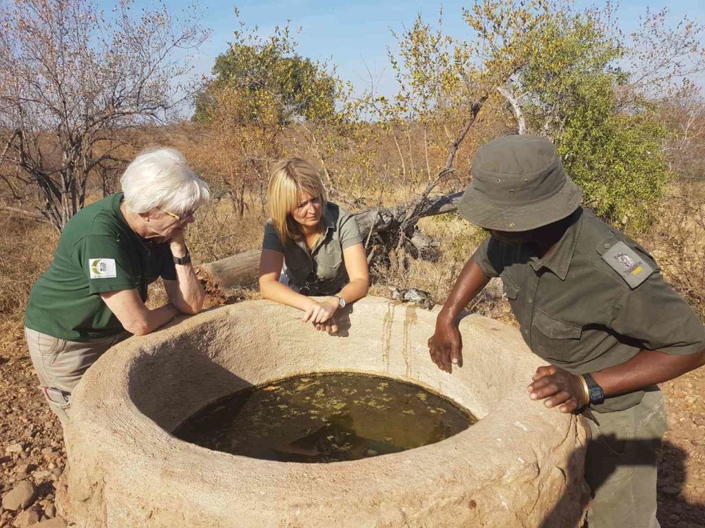 Jule Schwachhöfer mit Rangern im Kruger Park am Wasserloch